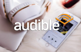 Audible logo med lydbok app i bakgrunn