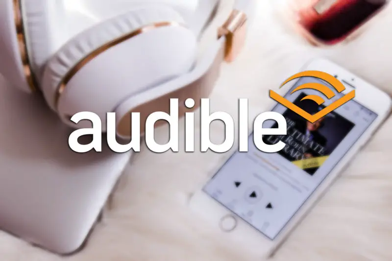 Audible logo med lydbok app i bakgrunn