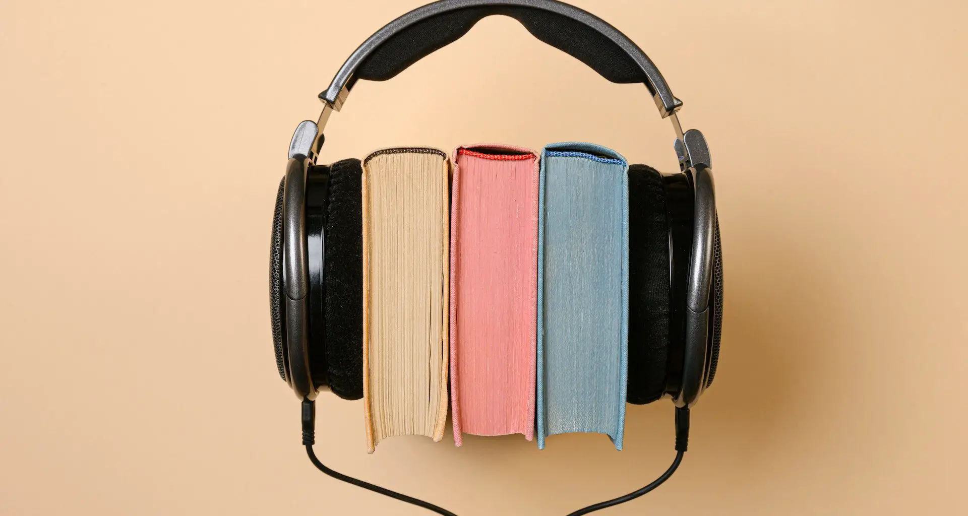 3 bøker med et øreklokker for å illustrere lydbøker